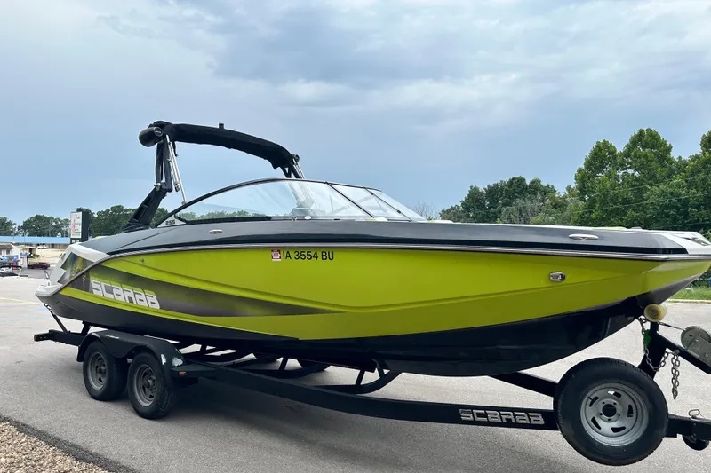 Slide: The Image of 2017 Scarab 255 boat in vibrant green on a trailer, parked outdoors. - 3