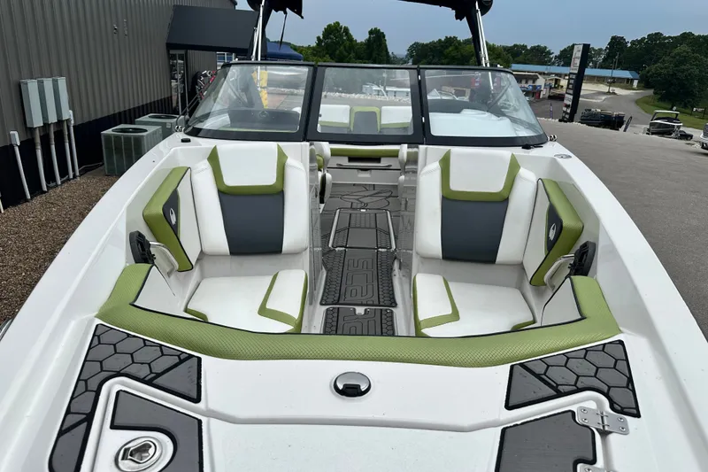 Slide: The Image of 2017 Scarab 255 boat interior with green and white seating, docked outdoors. - 11