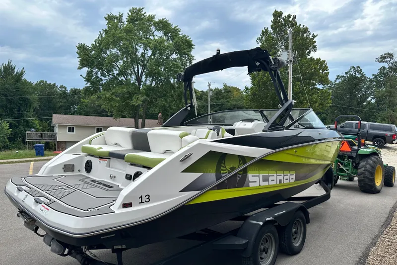 Slide: The Image of 2017 Scarab 255 boat on trailer, featuring sleek design and vibrant green accents. - 4