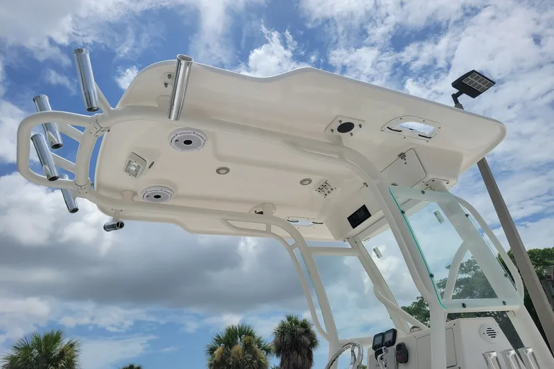 Slide: The Image of 2010 Everglades 243 Center Console boat with T-top under a partly cloudy sky. - 18