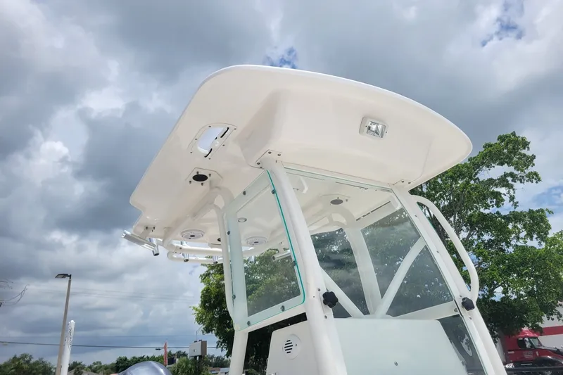 Slide: The Image of 2010 Everglades 243 Center Console boat under cloudy sky, showcasing T-top and console. - 20