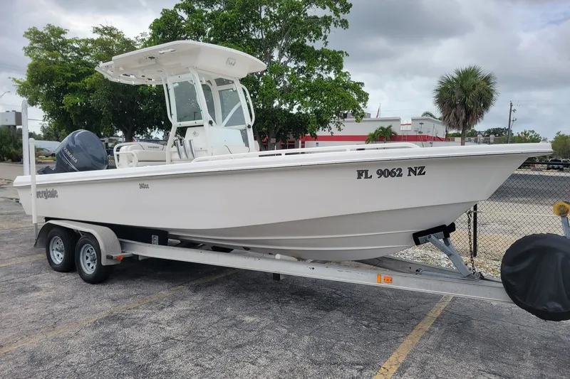 The Image of 2010 Everglades 243 Center Console boat on trailer, parked outdoors. - 0