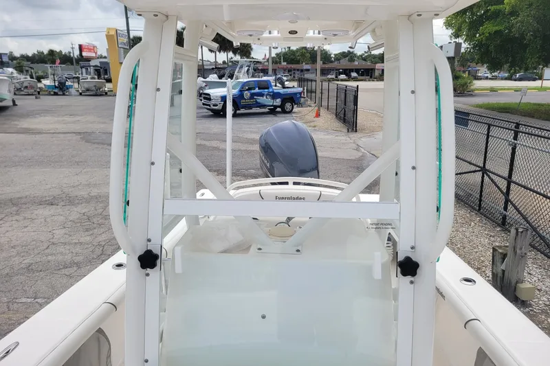 Slide: The Image of 2010 Everglades 243 Center Console boat with outboard motor, parked in a marina. - 13