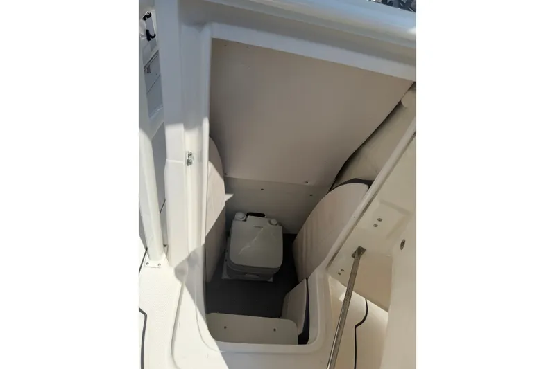 Slide: The Image of 2021 Robalo R222 Center Console interior storage compartment with portable toilet. - 13