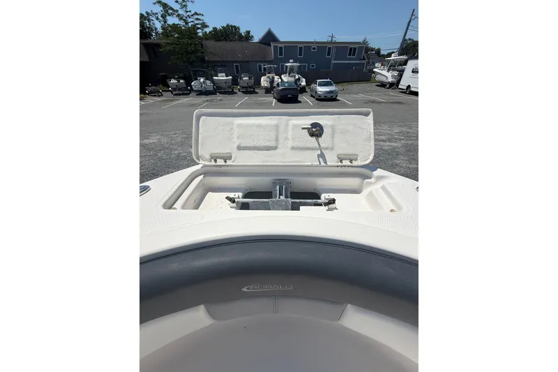 Slide: The Image of 2021 Robalo R222 Center Console boat anchor compartment open in parking lot. - 16