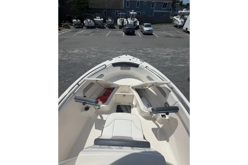 Slide: The Image of 2021 Robalo R222 Center Console boat with open storage compartments, parked in a marina. - 15