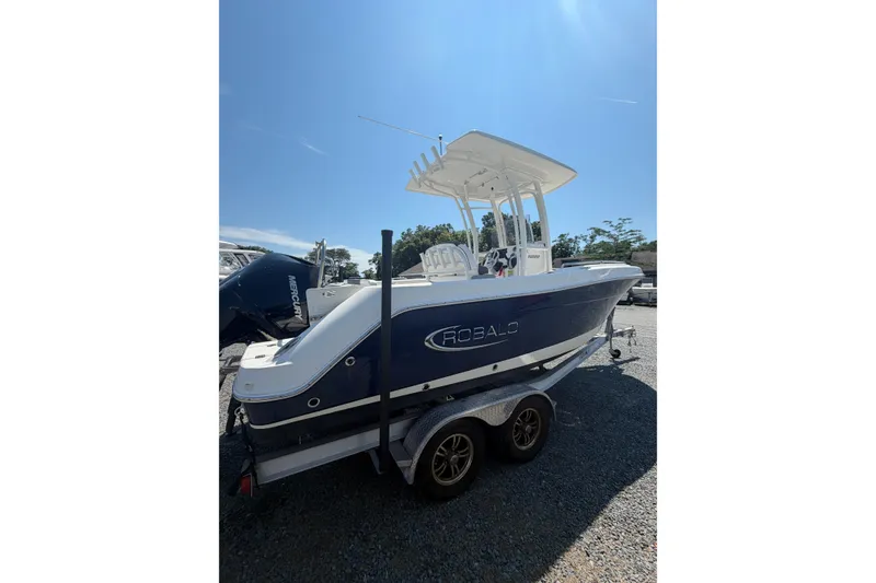 Slide: The Image of A 2021 Robalo R222 Explorer boat on a trailer, featuring a blue hull and white top. - 3