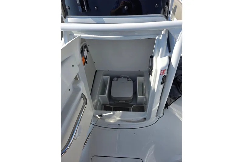 Slide: The Image of 2026 Finseeker 210 CC boat interior with compact storage compartment and portable toilet. - 18
