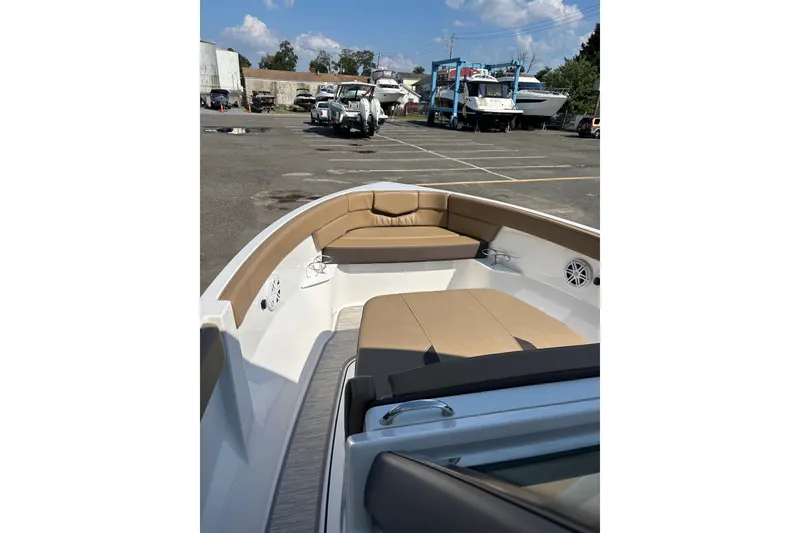Slide: The Image of 2027 Monterey Elite 25 OB boat with tan seating, parked in a marina. - 6