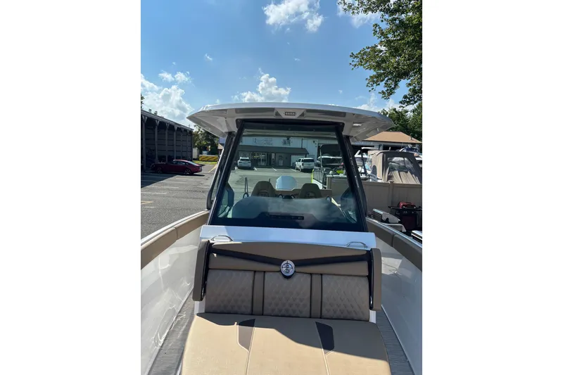 Slide: The Image of 2027 Monterey Elite 25 OB boat with sleek design, docked under a clear blue sky. - 5