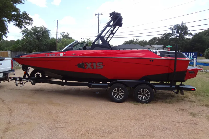 Slide: The Image of Red 2020 Axis A22 boat on trailer, parked outdoors, side view. - 5