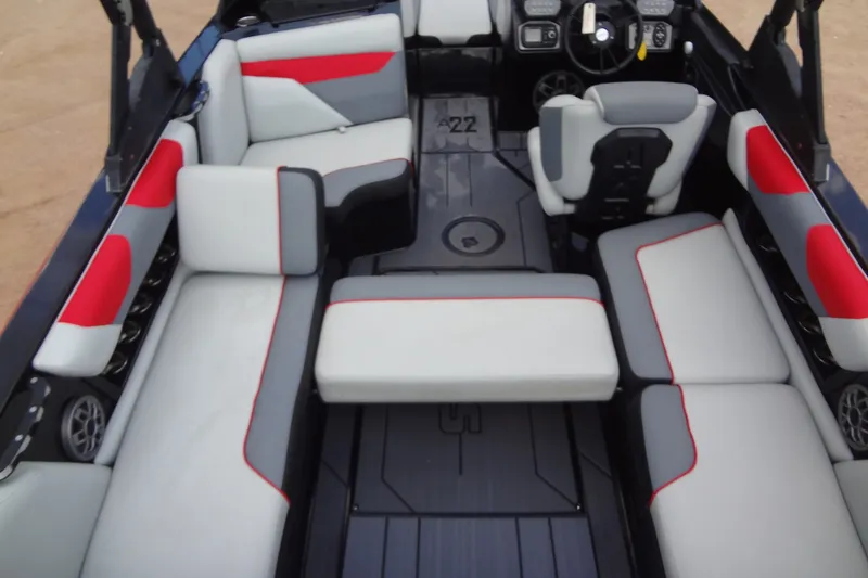 Slide: The Image of 2020 Axis A22 boat interior with gray and red seating, steering wheel, and dashboard. - 21