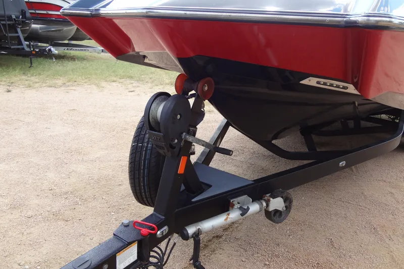 Slide: The Image of 2020 Axis A22 boat on trailer, red and black hull, parked on gravel. - 7
