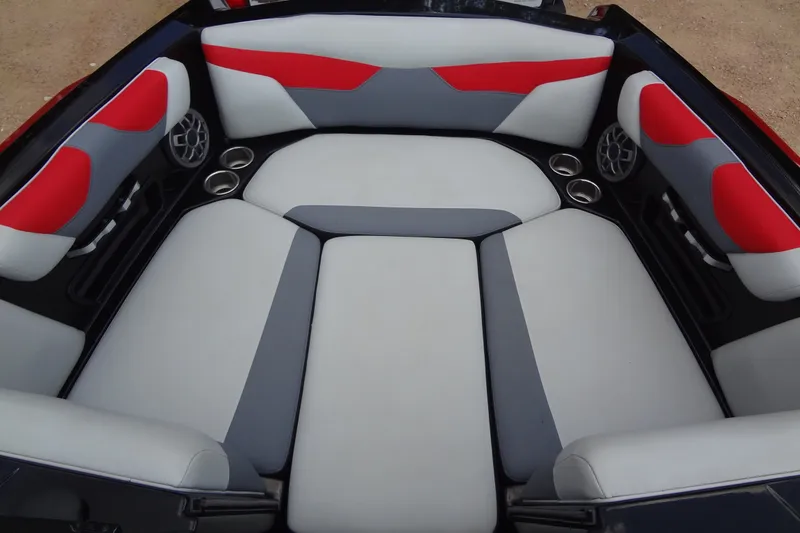 Slide: The Image of 2020 Axis A22 boat interior with red and gray seating, featuring cup holders and speakers. - 12