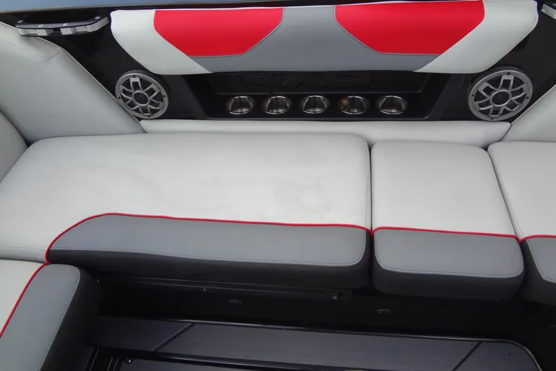 Slide: The Image of 2020 Axis A22 boat interior with gray and red seating, speakers, and cup holders. - 17