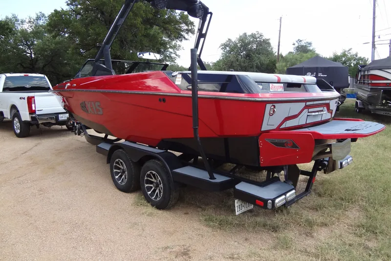 Slide: The Image of Red 2020 Axis A22 boat on trailer, parked outdoors near a white truck. - 4
