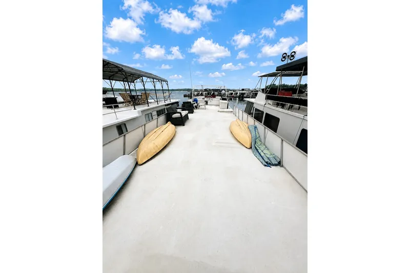 Slide: The Image of Houseboat deck with kayaks, under a blue sky. Lazy Days 14x60, 1980 model. - 18