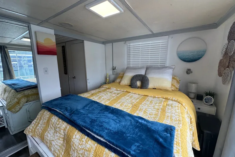 Slide: The Image of Cozy bedroom in a 1980 Lazy Days 14x60 houseboat, featuring vibrant decor and natural light. - 13