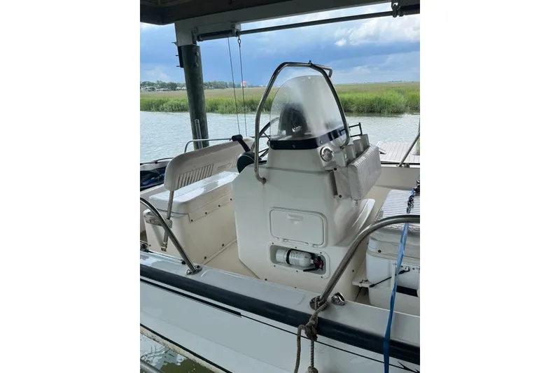 Slide: The Image of 2016 Boston Whaler 170 Montauk boat docked by a scenic waterfront. - 1