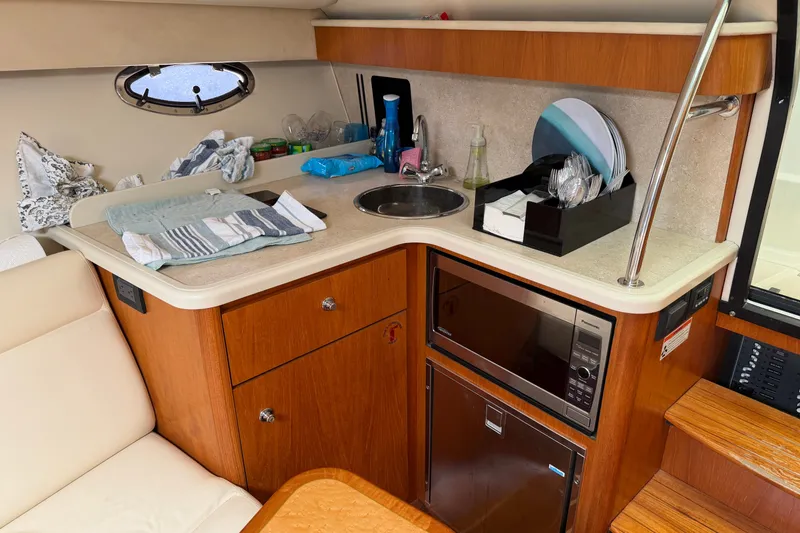 Slide: The Image of 2008 Tiara Yachts 3000 Open interior galley with sink, microwave, and storage. - 11