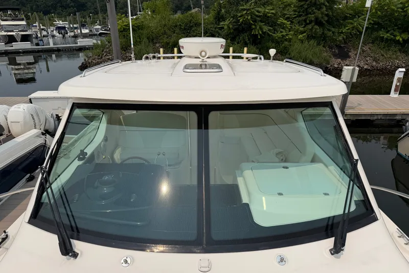 Slide: The Image of 2008 Tiara Yachts 3000 Open at marina, showcasing cockpit and windshield. - 3