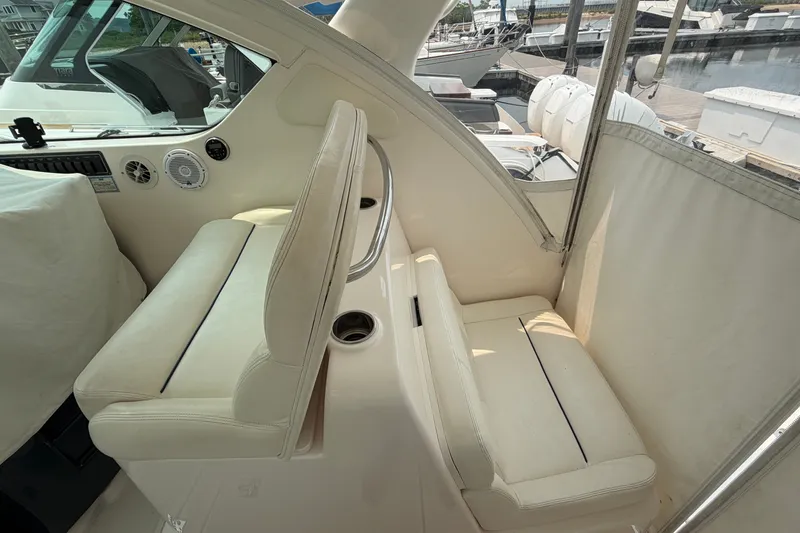 Slide: The Image of 2008 Tiara Yachts 3000 Open interior with white seating and marina view. - 6