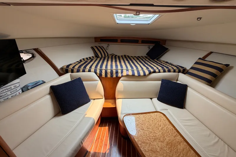 Slide: The Image of 2008 Tiara Yachts 3000 Open cabin interior with striped bedding and cozy seating. - 17