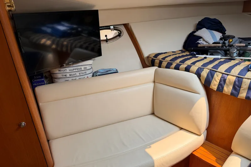Slide: The Image of Interior of 2008 Tiara Yachts 3000 Open with cozy seating and striped bedding. - 15