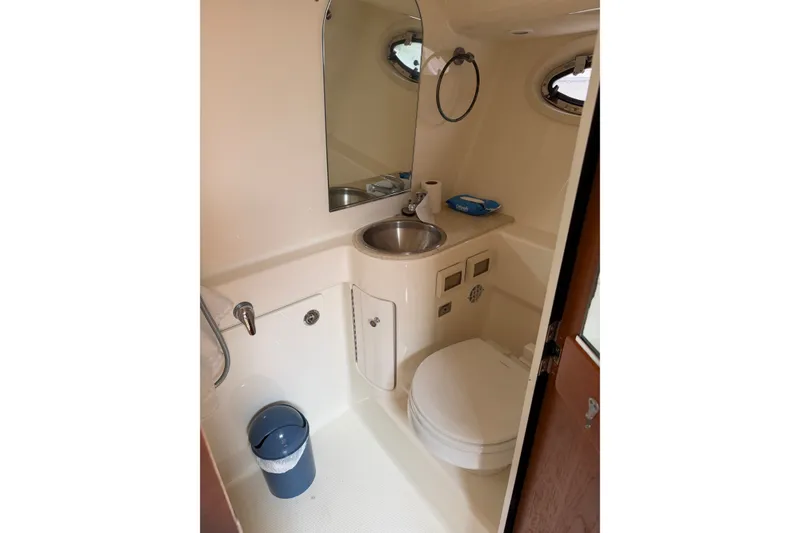 Slide: The Image of Compact bathroom in 2008 Tiara Yachts 3000 Open, featuring sink, toilet, and mirror. - 13