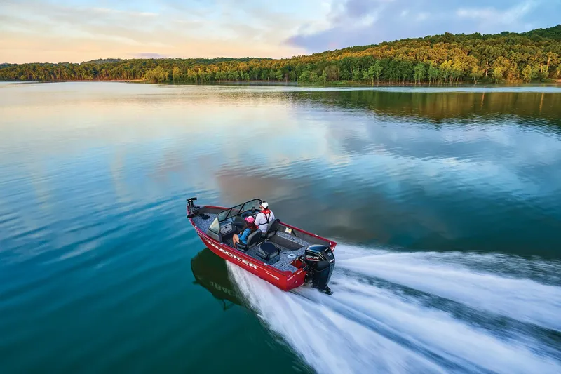 Slide: The Image of Manufacturer Provided Image: 2025 Tracker Pro Guide V-16 WT boat speeding on a serene lake with forested shoreline. - 51