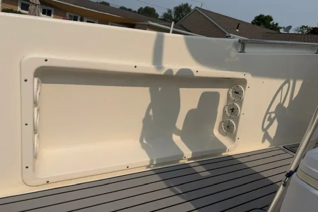 Slide: The Image of 2021 Bulls Bay 230 Center Console boat interior with rod holders and steering wheel shadow. - 14