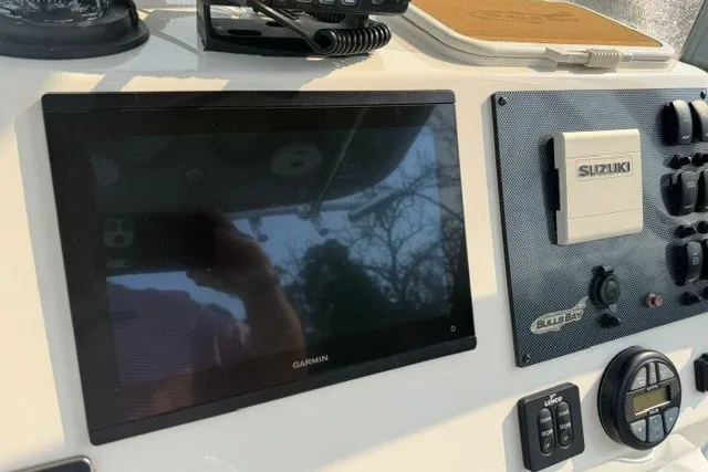 Slide: The Image of 2021 Bulls Bay 230 Center Console dashboard with Garmin and Suzuki controls. - 30