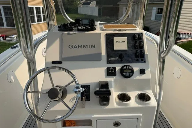 Slide: The Image of 2021 Bulls Bay 230 Center Console boat dashboard with Garmin and Suzuki controls. - 31