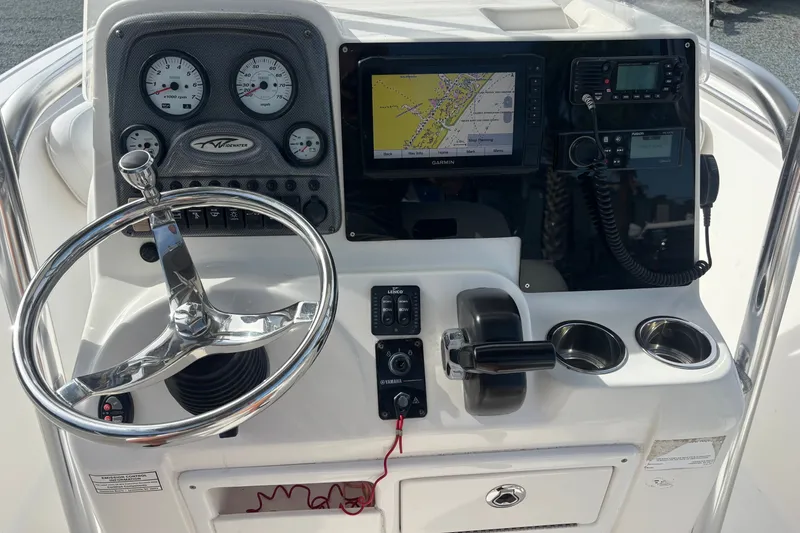 Slide: The Image of 2015 Tidewater 210 LXF boat dashboard with steering wheel, gauges, and navigation system. - 8