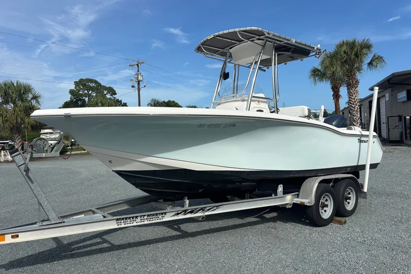 Slide: The Image of 2015 Tidewater 210 LXF boat on trailer, parked outdoors under clear blue sky. - 4