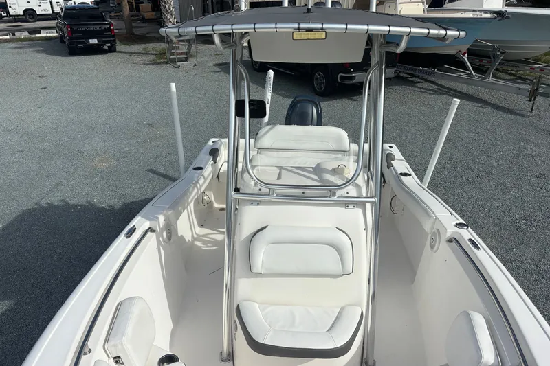 Slide: The Image of 2015 Tidewater 210 LXF boat with white seating and T-top in a marina setting. - 7