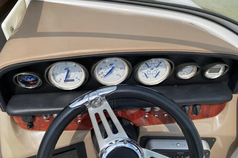 Slide: The Image of Dashboard of a 2008 Four Winns H220 boat with gauges and steering wheel. - 37