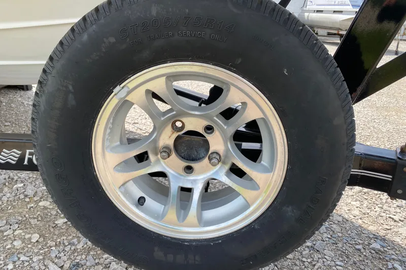 Slide: The Image of Trailer wheel of a 2008 Four Winns H220 boat, featuring ST205/75R14 tire. - 21