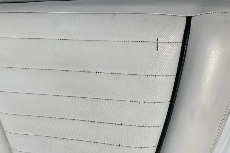 Slide: The Image of White upholstery with visible stitching on a 2008 Four Winns H220 boat seat. - 70