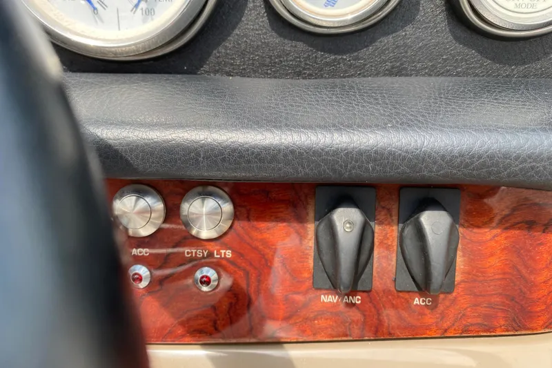 Slide: The Image of Dashboard controls of a 2008 Four Winns H220 boat, featuring switches and gauges. - 52