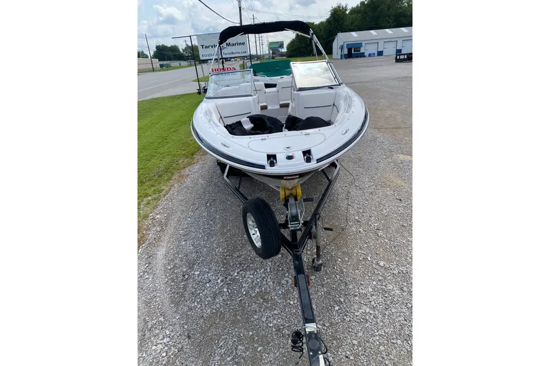 Slide: The Image of 2008 Four Winns H220 boat on trailer, parked outdoors near a marine dealership. - 66