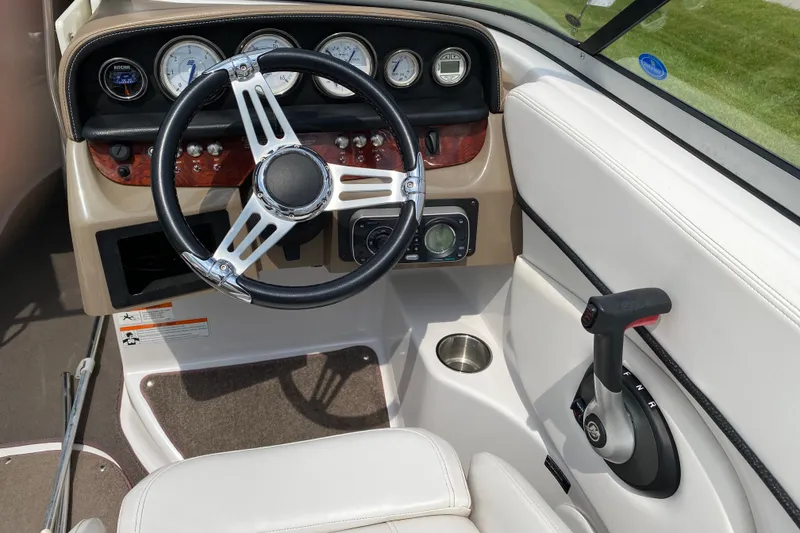 Slide: The Image of 2008 Four Winns H220 boat dashboard with steering wheel and control panel. - 32