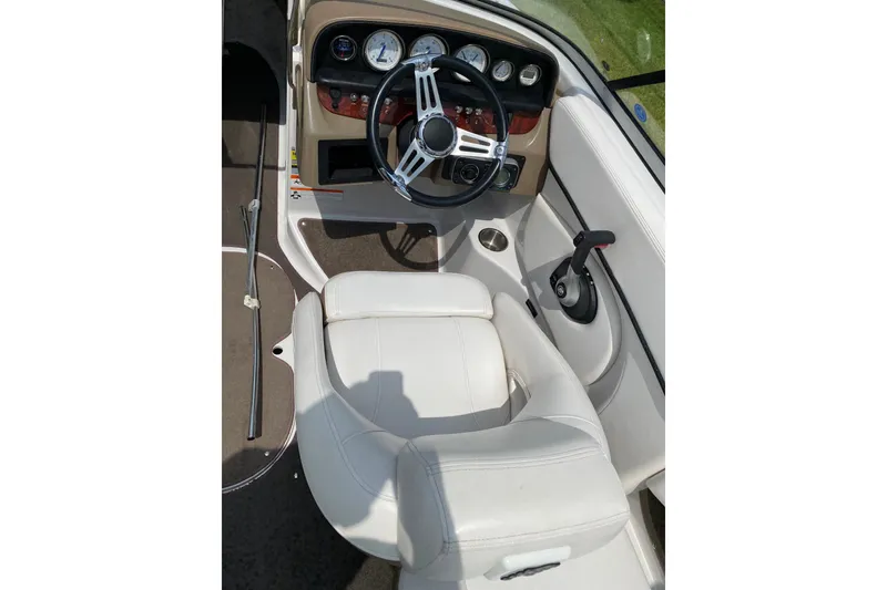 Slide: The Image of 2008 Four Winns H220 boat interior with steering wheel, dashboard, and white seating. - 30