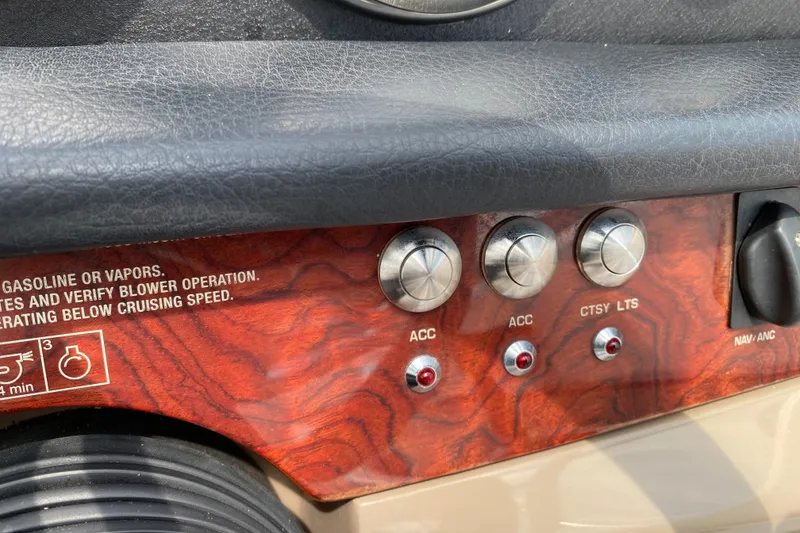 Slide: The Image of Control panel of a 2008 Four Winns H220 boat with wood finish and labeled switches. - 49