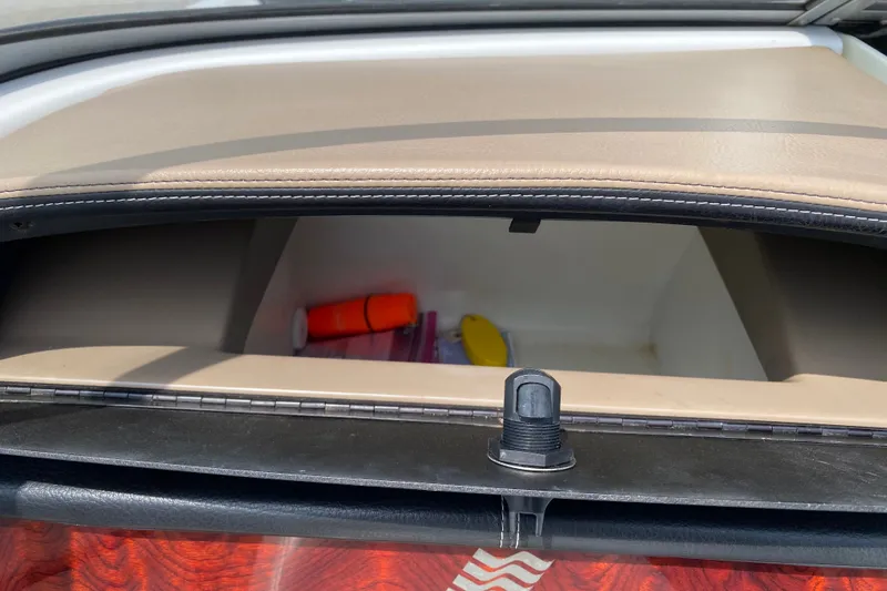 Slide: The Image of Storage compartment in a 2008 Four Winns H220 boat, containing safety equipment. - 47