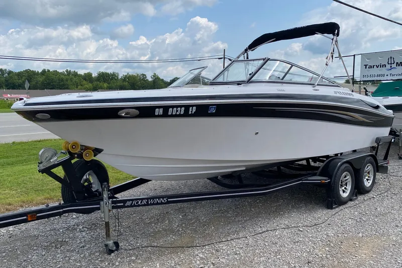 Slide: The Image of 2008 Four Winns H220 boat on trailer, parked outdoors under cloudy sky. - 63