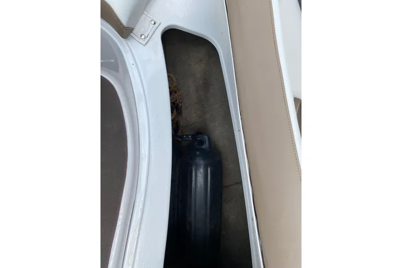 Slide: The Image of Storage compartment in a 2008 Four Winns H220 boat with a black fender. - 74