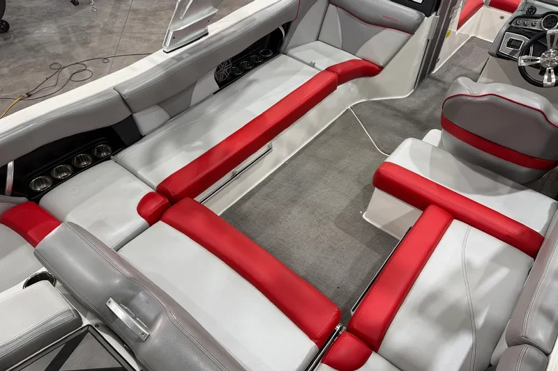 Slide: The Image of 2017 MasterCraft X46 interior with red and gray seating, cup holders, and steering wheel. - 8