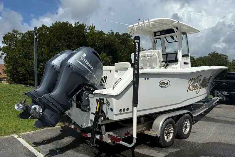 Slide: The Image of 2022 Sea Hunt Gamefish 27FS boat on trailer with Yamaha engines, parked outdoors. - 31