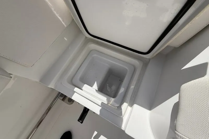 Slide: The Image of 2022 Sea Hunt Gamefish 27FS boat storage compartment, open lid, white interior. - 39